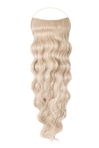 Close-up of a woman wearing long, wavy Syn Halo hair extensions blending naturally with her hair.